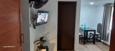 a living room with a table and a television on a wall at Randukai Farm House in Athirappally