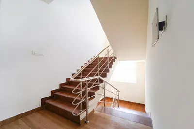 a staircase in a house with a metal railing at Via Aarudra s Residency in Coimbatore