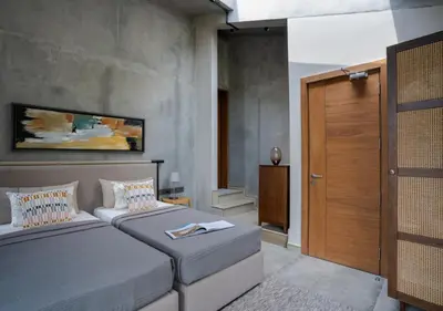 a bedroom with two beds and a wooden door at LohonoStays Villa Amani 8B in Coonoor