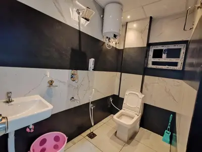 a small bathroom with a sink and a toilet at Eve Service apartment in Mysore