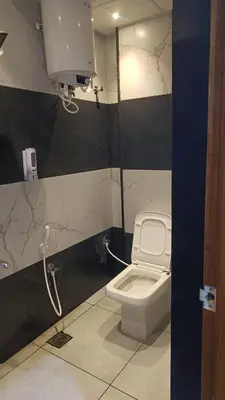 a bathroom with a toilet and a shower stall at Eve Service apartment in Mysore