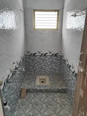 a bathroom with a tiled floor and a toilet at MMVK Homestay AC, Spacious & Comfortable Entire Home Just For You in Pollāchi