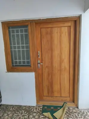 a wooden door in a room with a window at MMVK Homestay AC, Spacious & Comfortable Entire Home Just For You in Pollāchi