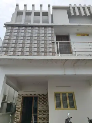 a white building with a balcony and a window at MMVK Homestay AC, Spacious & Comfortable Entire Home Just For You in Pollāchi