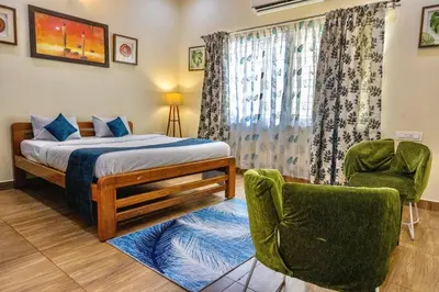 a bedroom with a bed and two chairs at Beedu - Backpackers Hostel in Mysore