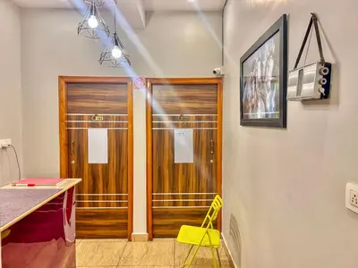 a room with two wooden doors and a yellow stool at Beedu - Backpackers Hostel in Mysore