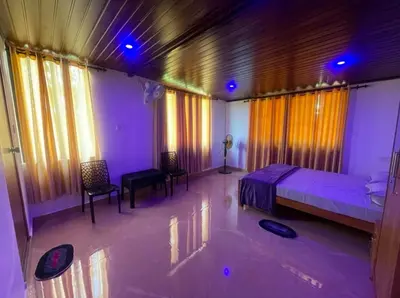 a bedroom with a bed and a table and chairs at Tjmaryland villa in Pinangode