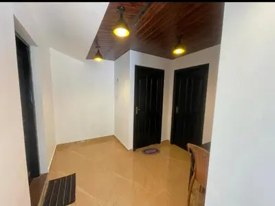 a room with two black doors and a tile floor at Tjmaryland villa in Pinangode