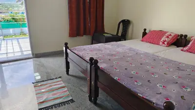 a bedroom with a bed with a purple comforter at Alappat Lodge Masinagudi in Masinagudi
