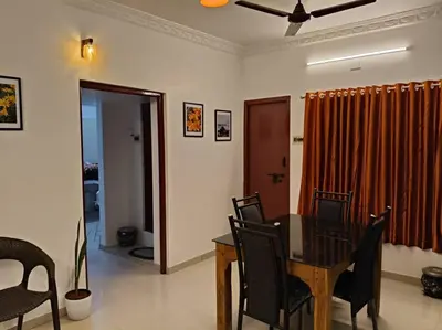 a dining room with a table and chairs at Padmam Service Apartments - 2BHK in Singānallūr