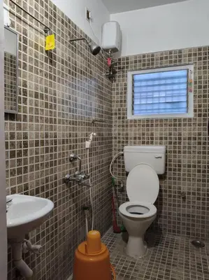 a bathroom with a toilet and a sink at Padmam Service Apartments - 2BHK in Singānallūr