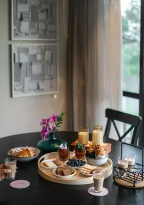 a table topped with plates of food and candles at LohonoStays Amani Villa 10A in Coonoor