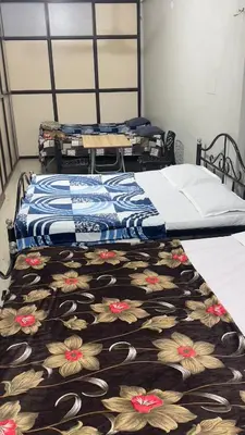 two beds in a room with a bedspread with flowers at Mysuru-hotel in Mysore