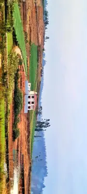 a house on a hill next to a body of water at AJ Groups B&B Residency in Ooty