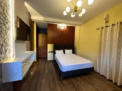 a bedroom with a bed and a dresser in it at RR Forest View in Ooty