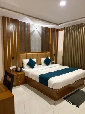 a bedroom with a large bed with blue pillows at Symphony in Ooty