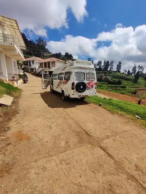 a white camper van parked in a driveway at Ooty Horizon Heights in Ooty