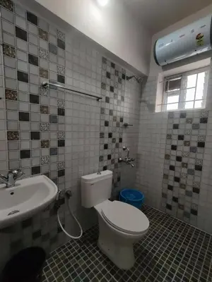 a bathroom with a toilet and a sink at Ooty Horizon Heights in Ooty