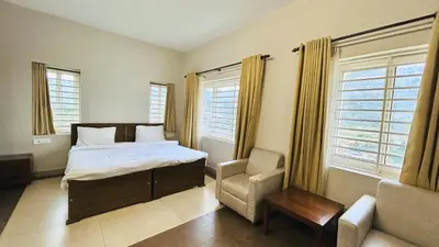 a bedroom with a bed and a chair and windows at Away From Home - 4 - Rooms In Ooty, Home Stay Ooty in Ooty