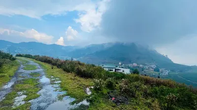 a winding road on a hill with mountains in the background at Away From Home - 4 - Rooms In Ooty, Home Stay Ooty in Ooty