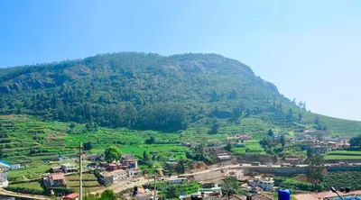 a village in front of a mountain at Away From Home - 5 - Rooms In Ooty, Home Stay Ooty in Ooty