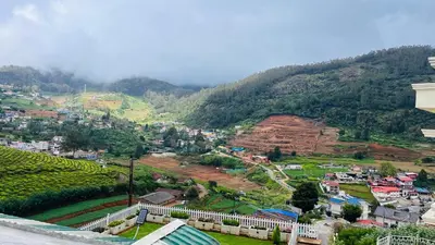 a view of a city with mountains in the background at Away From Home - 5 - Rooms In Ooty, Home Stay Ooty in Ooty