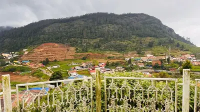 a view of a hill with a town and a mountain at Away From Home - 5 - Rooms In Ooty, Home Stay Ooty in Ooty