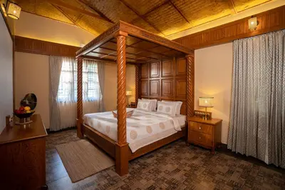 a bedroom with a canopy bed in a room at Regenta Resort Mysore Tropical Village in Chāmundi