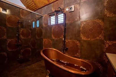 a bathroom with a tub and a window at Regenta Resort Mysore Tropical Village in Chāmundi