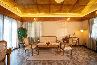 a living room with a couch and a table and chairs at Regenta Resort Mysore Tropical Village in Chāmundi