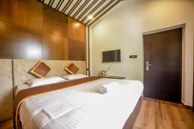 a bedroom with a large white bed and a television at The Haven by Xplore Indo in Ooty