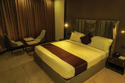 a hotel room with a bed and a table and chairs at BINI Heritage in Trichūr