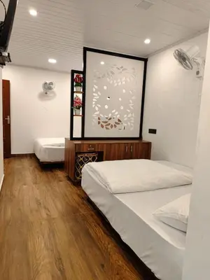 a bedroom with two beds and a painting on the wall at Birdwing Cottage, Munnar in Munnar