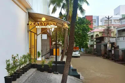 a sign for a restaurant on a street with palm trees at Eka Lyf Inn in Coimbatore