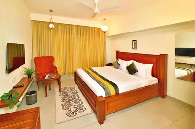 a bedroom with a bed and a chair in it at Eka Lyf Inn in Coimbatore