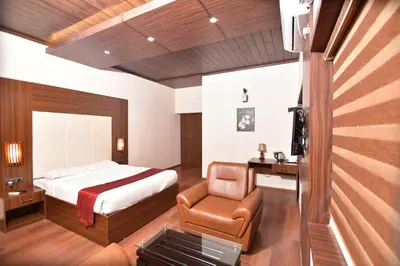 a bedroom with a bed and a chair at The Garuda Hotels in Trichūr