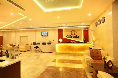 a lobby of a salon with a yellow couch and chairs at The Garuda Hotels in Trichūr
