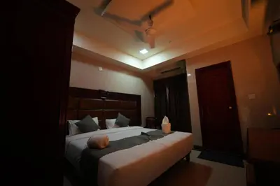 a bedroom with a large bed in a room at Mazus Urban Express in Mysore