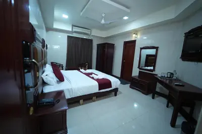 a bedroom with a bed and a desk and a mirror at Mazus Urban Express in Mysore