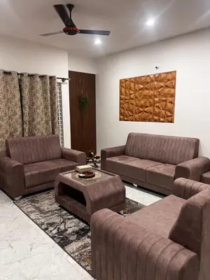 a living room with two couches and a table at Sahar Home Stay 01 in Mysore