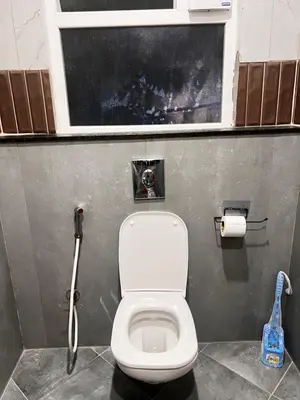 a bathroom with a white toilet in a stall at Sahar Home Stay 01 in Mysore