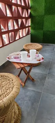 a table with two cups on it with two chairs at SAHAR HOMEstay 02 in Mysore