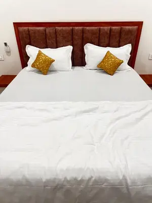 a large white bed with two pillows on it at SAHAR HOMEstay 02 in Mysore