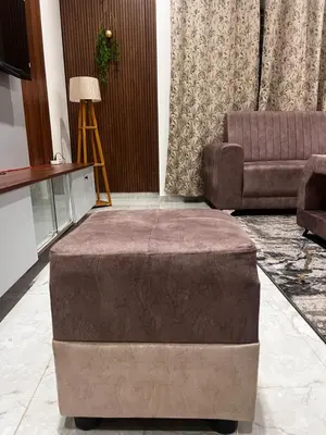 a large ottoman in a living room with a couch at SAHARHOMEstay O3 in Mysore