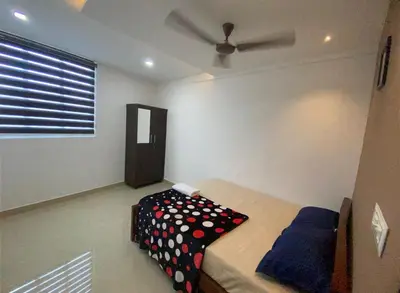 a bedroom with a bed and a ceiling fan at moona apartments in Malappuram