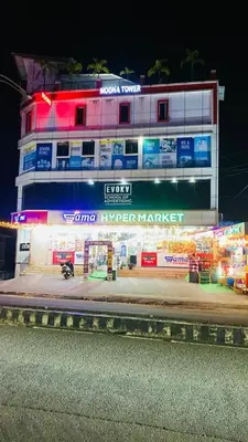 a building with neon signs on the side of it at moona apartments in Malappuram