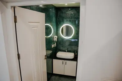 a bathroom with a sink and two mirrors at Ethnic Villa Wayanad in Kenichira