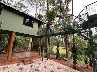 a man standing on a balcony of a tree house at Jungle Getaway Wayand in Pulpally