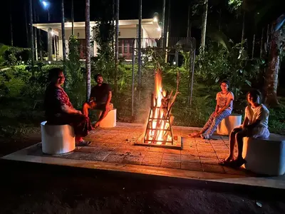 a group of people sitting around a fire pit at Jungle Getaway Wayand in Pulpally