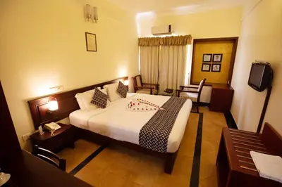 a hotel room with a large bed and a desk at Hotel Afrad International in Kondotti